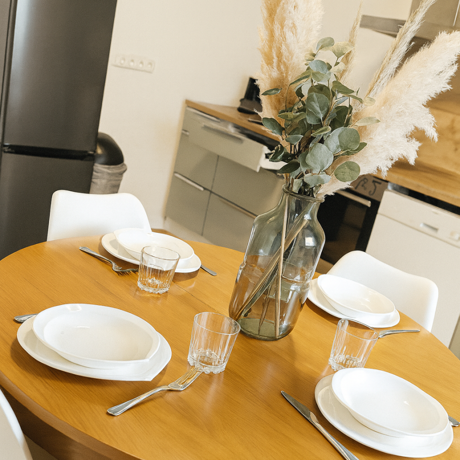 Küche Ferienhaus Gedeckter Runder Küchentisch im Ferienhaus mit Küche im Hintergrund